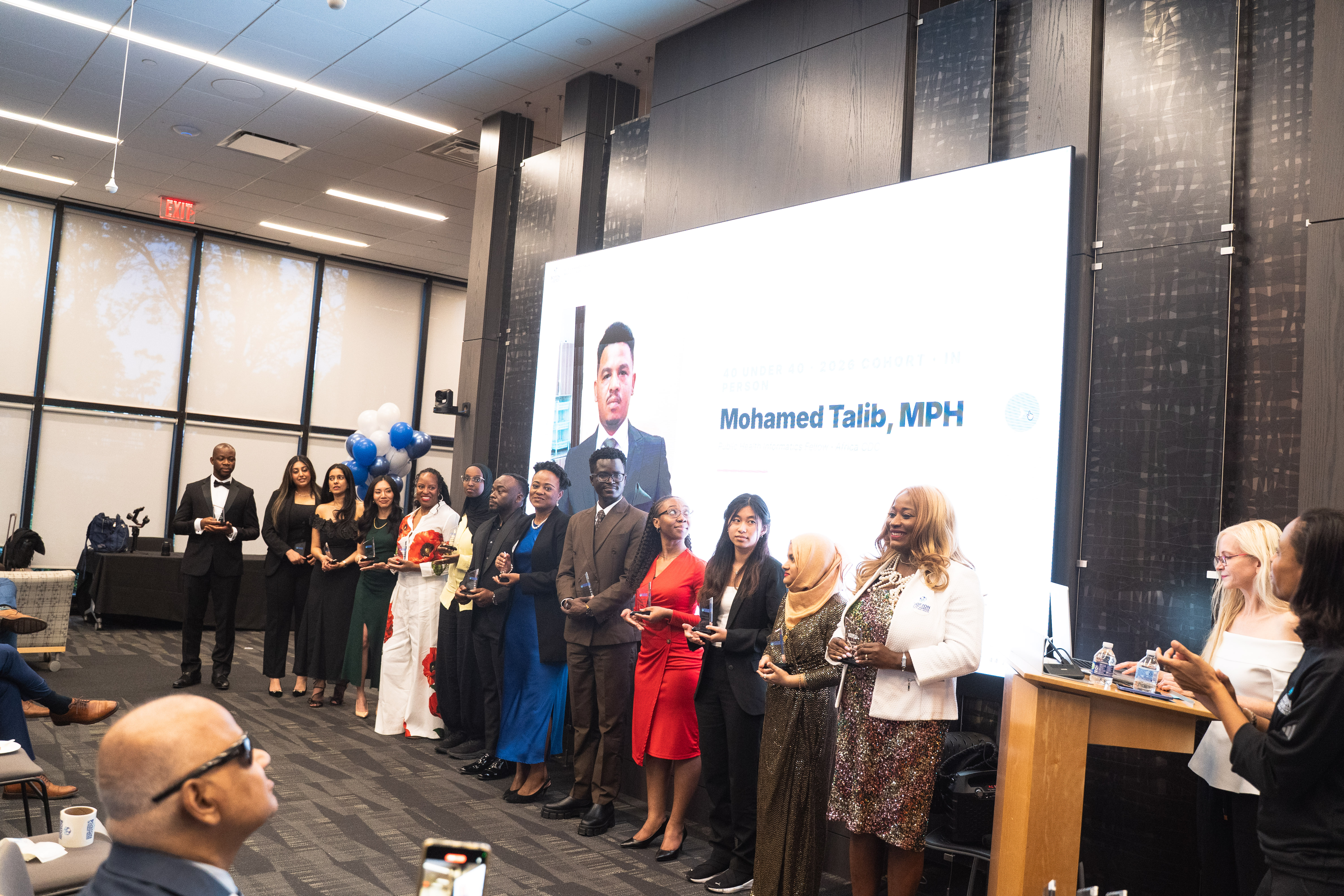 All 40 Under 40 honorees gathered together in front of the projection screen.