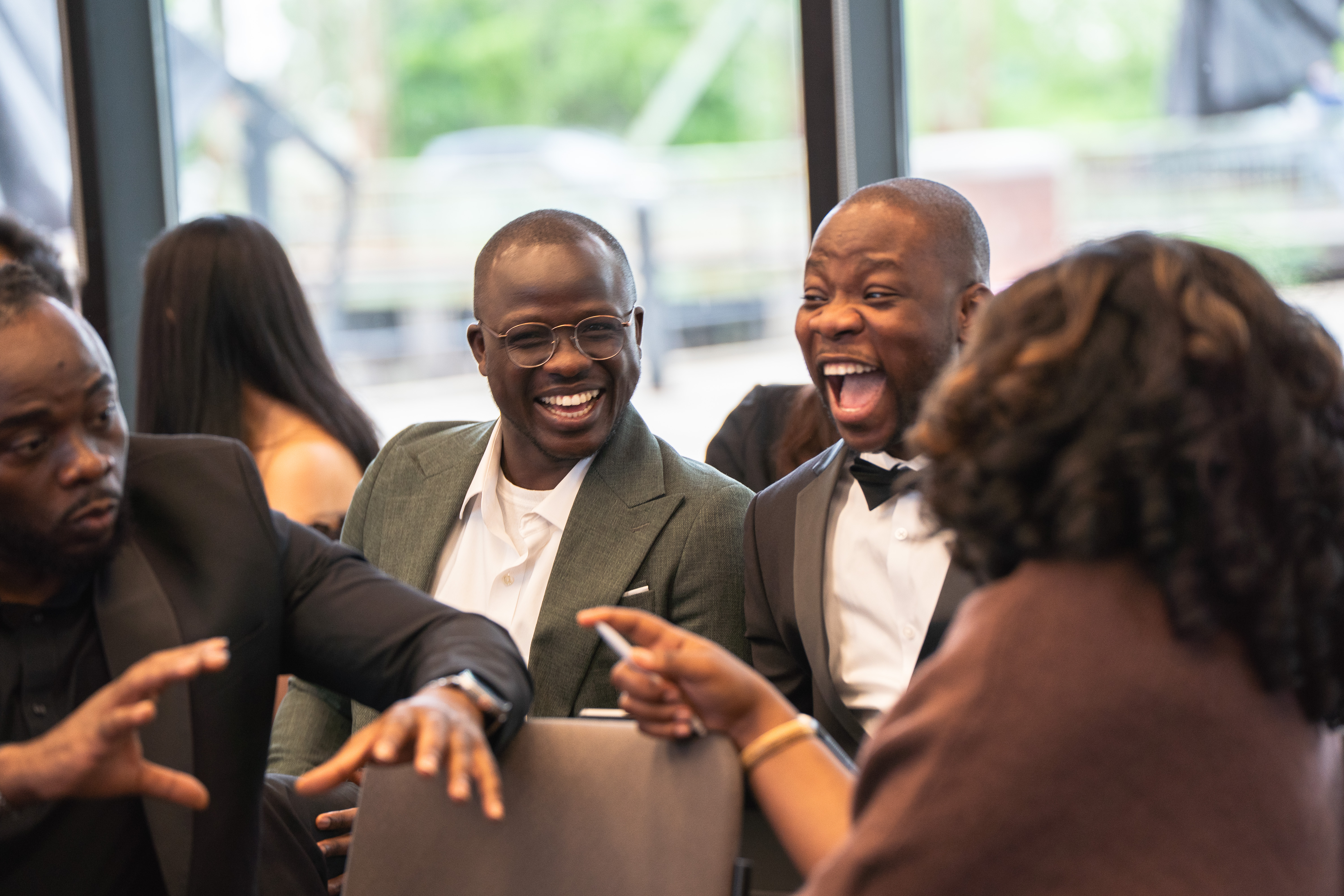 Three 40 Under 40 Public Health Catalysts laughing together in conversation near the windows.