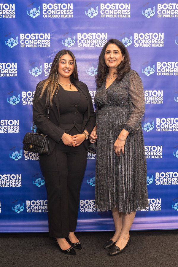 Two honorees on the BCPH backdrop, one in a black pantsuit and one in a long shimmery dress.