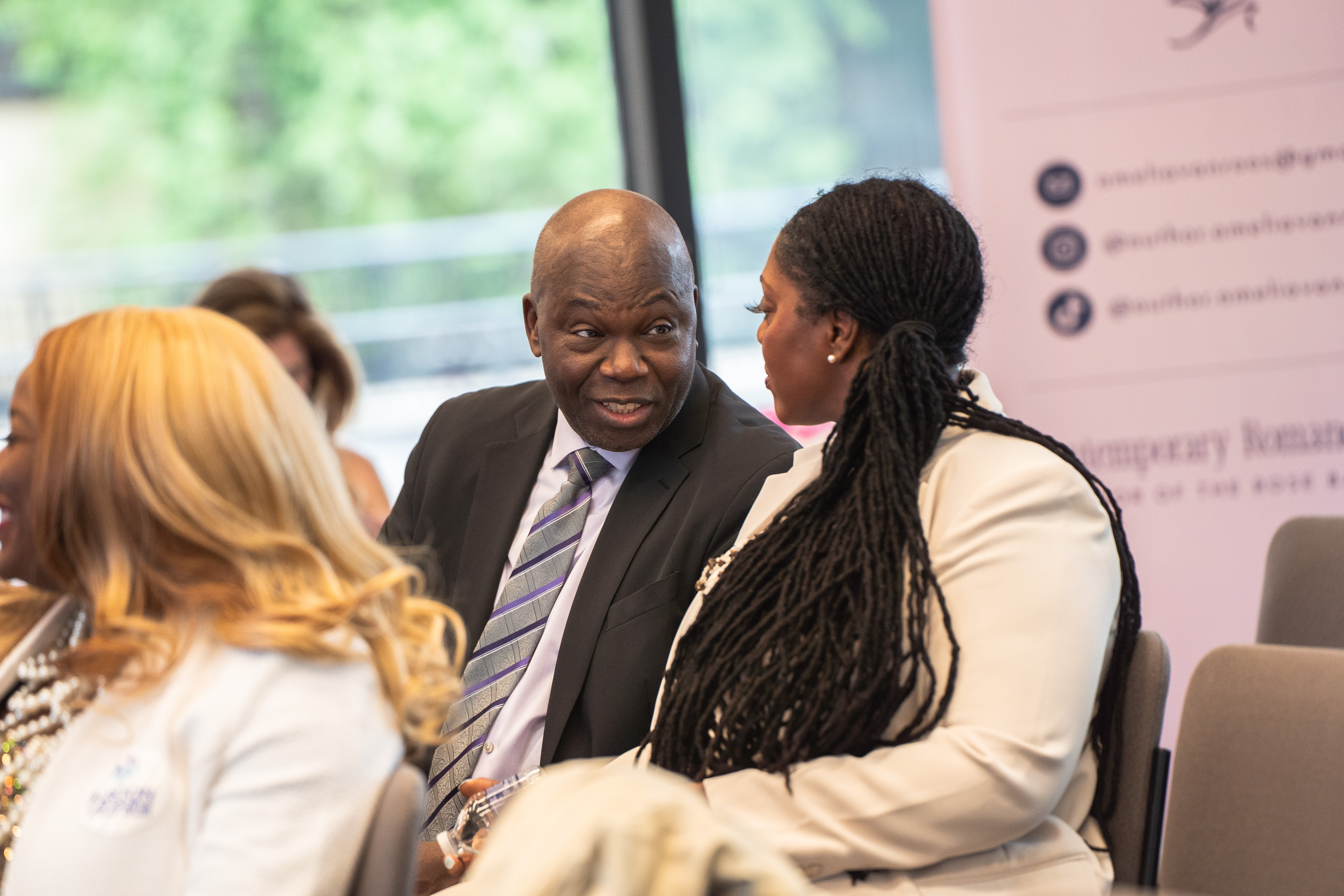 Dr. Kamilah Woodson talking with a colleague before the program begins.