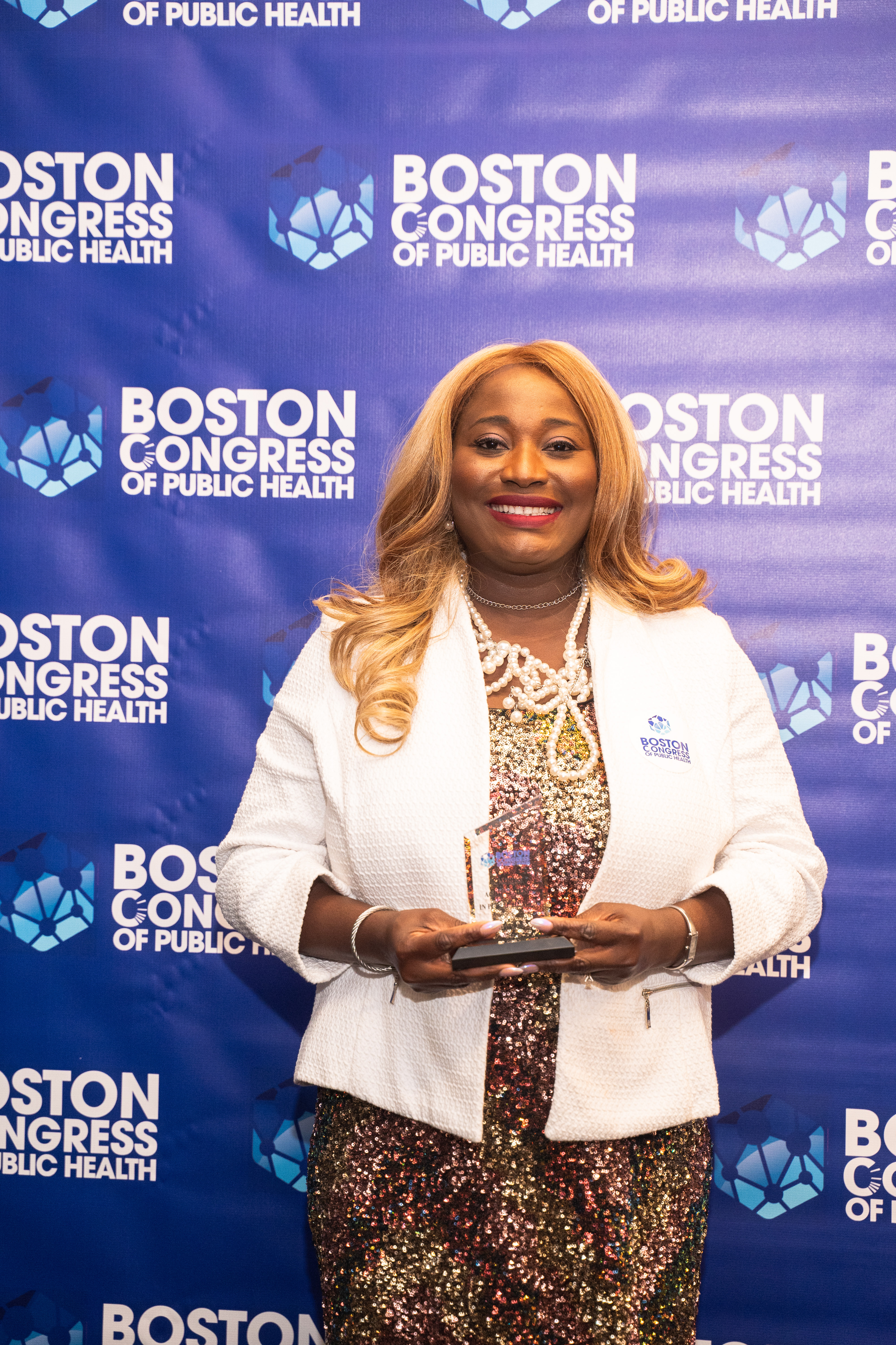 Dr. Oluwatosin Olateju with her trophy on the BCPH backdrop.