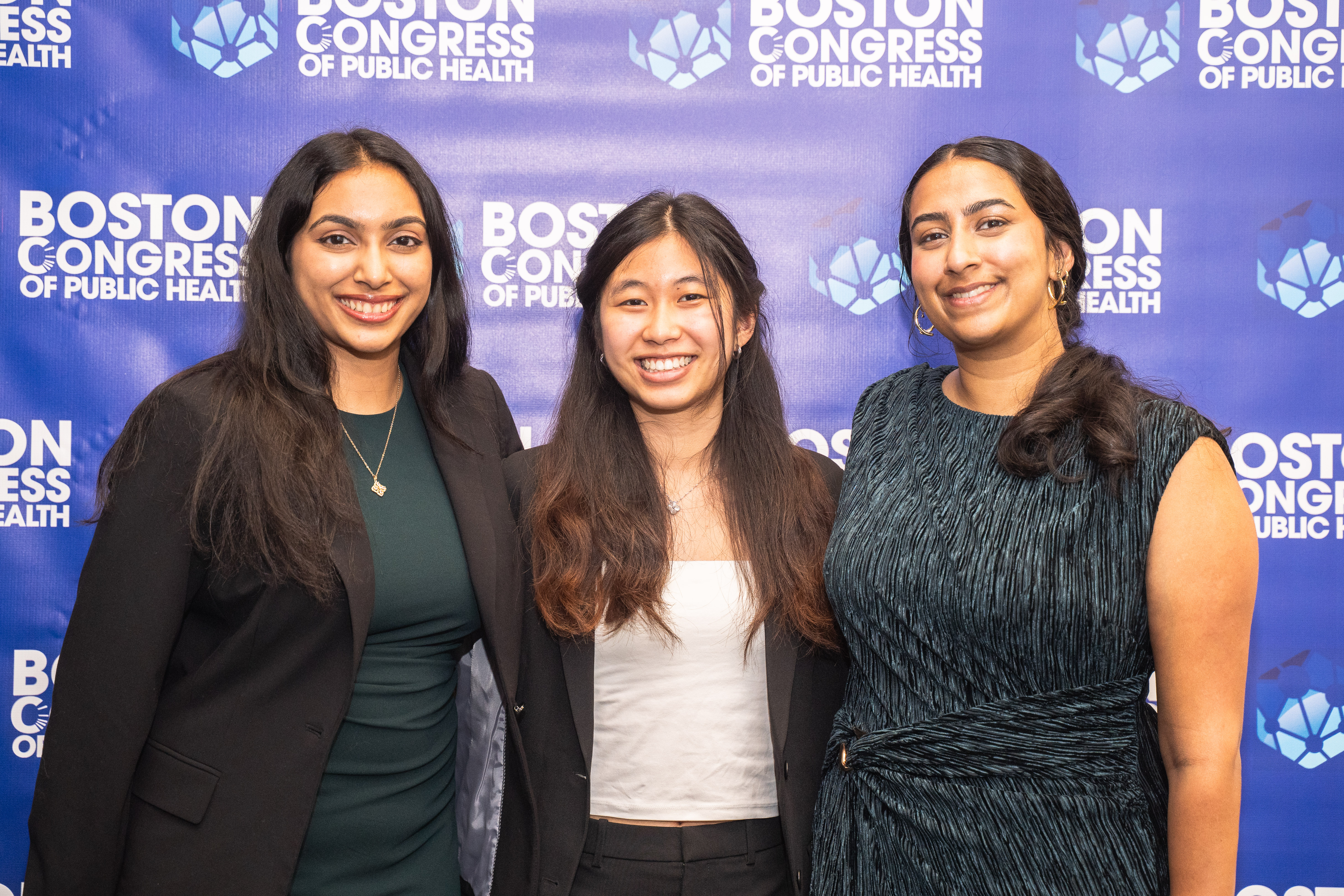 Three honorees on the BCPH backdrop: one in a dark blazer and dress, one in a white blouse and dark slacks, and one in a dark patterned dress.